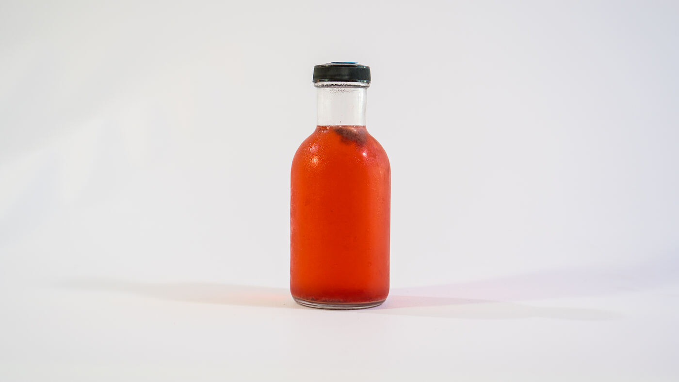 The materials for a DIY kombucha starter kit: gallon jar, tea, sugar, cloth and bottles
